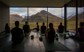 Group of people in a yoga class with a view of mountains.